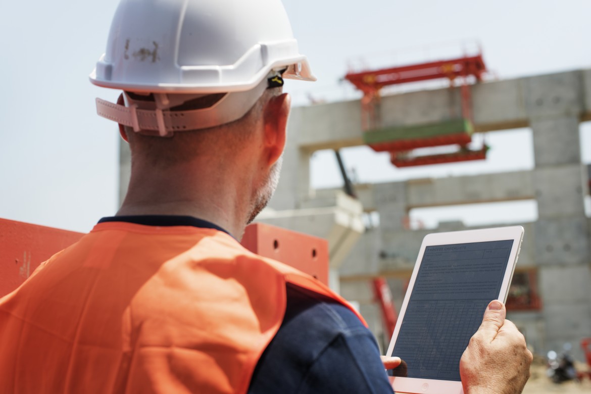 Construction worker using a digital tablet on-site to improve project efficiency and reduce the construction skill gap